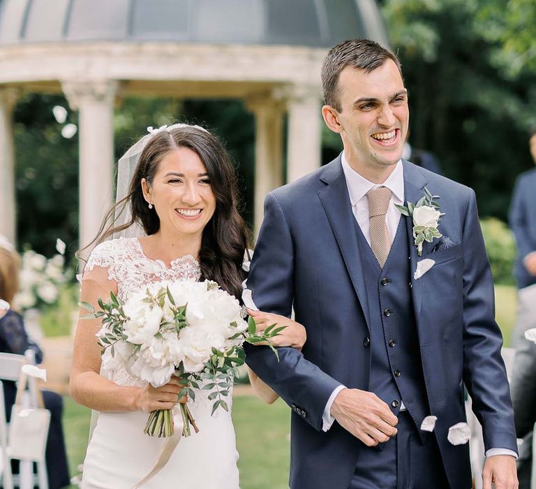 Bride in a Kelly Faetanini wedding dress holding a white wedding bouquet 