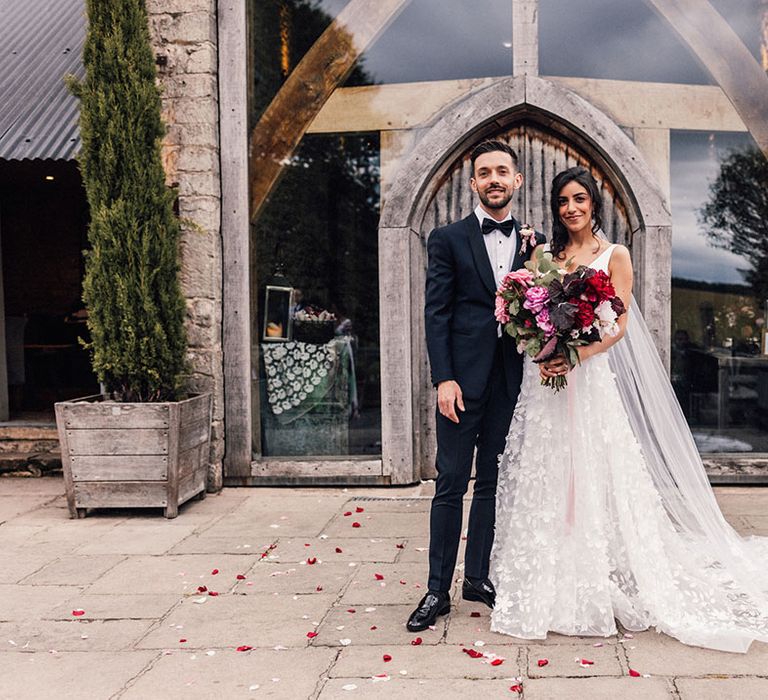 Cripps Barn wedding with the bride in a Savin London wedding dress and groom in traditional tuxedo 