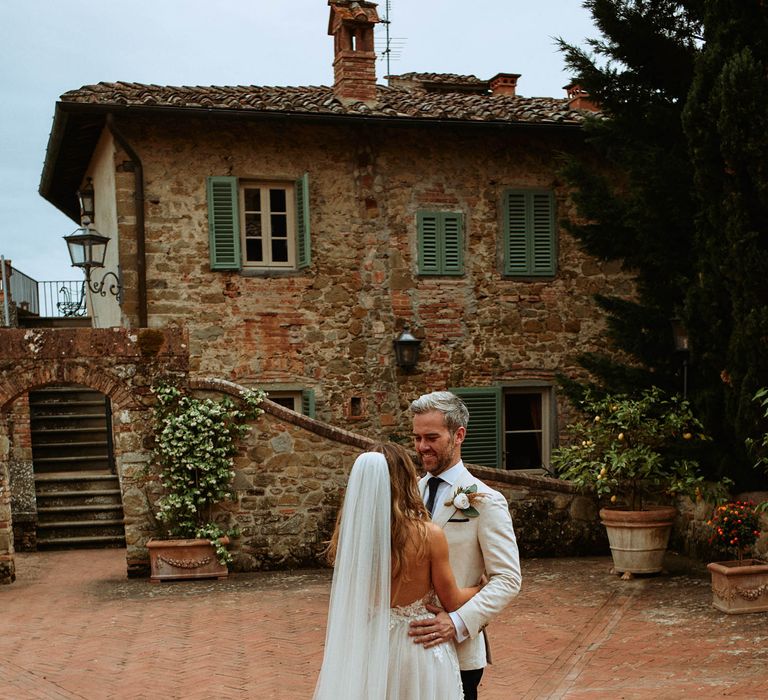 Bride in tulle wedding dress and veil with groom at Italian villa wedding