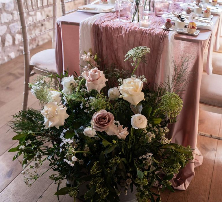 Modern wedding tablescape with lavender tablecloth, lilac tulle table runner, blush garden rose centrepieces, tea light candles and a trio of mini desserts with large garden rose, eucalyptus, baby's-breath and foliage flower arrangement 