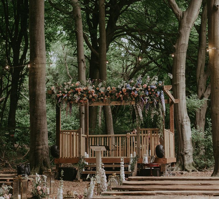 Lila's Wood woodland wedding venue with wooden gazebo decorated with pastel wildflowers for fairytale themed day 