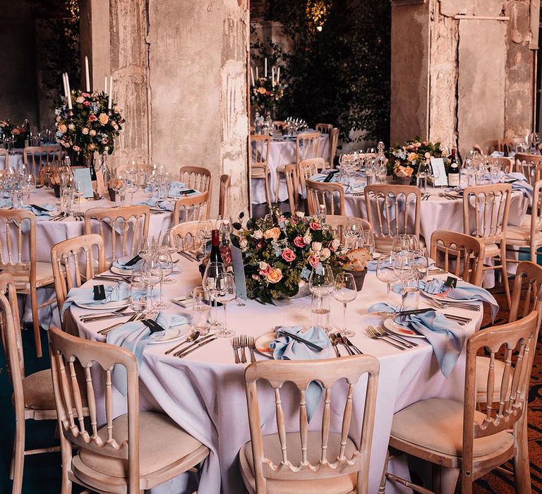 Baby blue napkins and menu card for the country house wedding venue with a floral table centrepiece and fake wedding candles 