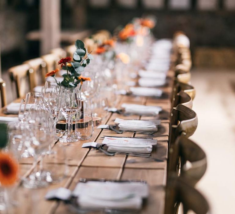 Classic rustic wedding tablescape with floral centrepieces on wooden tree stumps at Templars Barn wedding venue