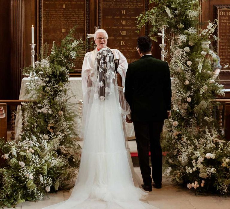 Bride in off the shoulder layered tulle wedding dress and floral embroidered cathedral-length veil at Inner Temple Hall with groom in bottle green velvet grooms suit