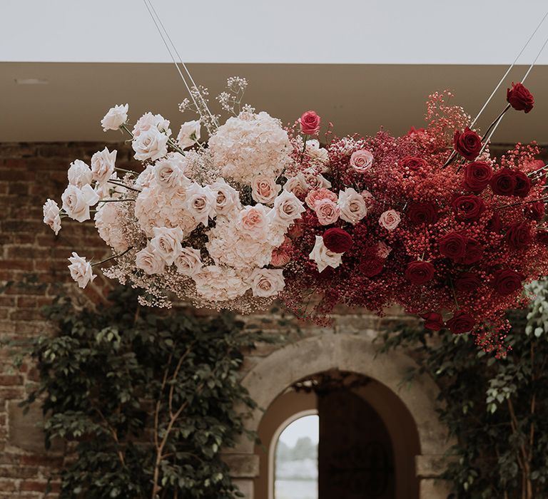 Pretty pink and red wedding flower cloud installation 