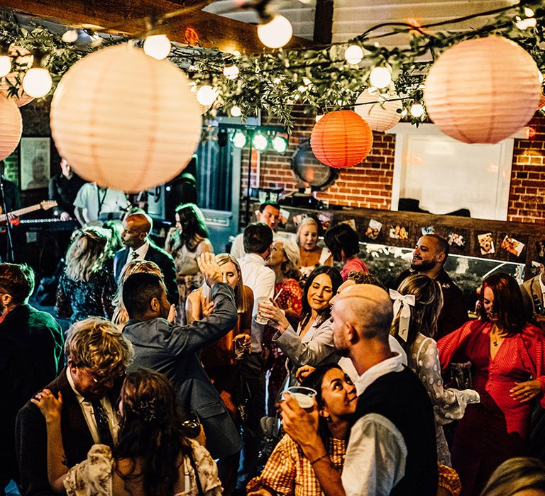 East Quay wedding venue ceiling decorated with festoon lights, lanterns and ivy wedding decorations 