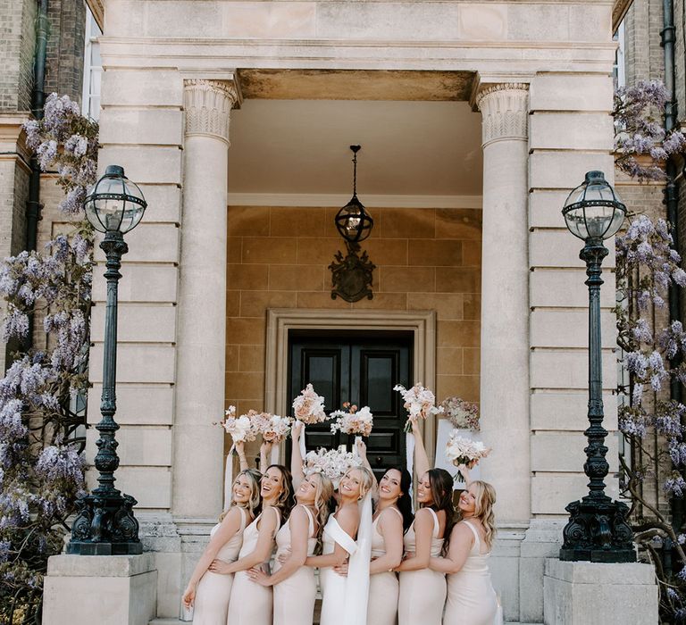 Bridal party in pale pink bridesmaid dresses with bouquets with bride in Eva Lendel wedding dress 