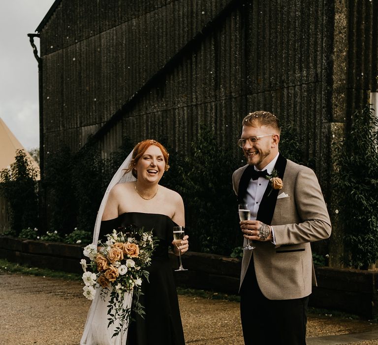 The bride and groom pose together for cute couple wedding photo at autumn rustic wedding 