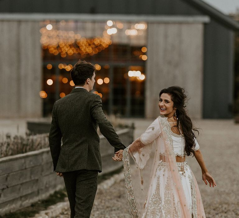 The bride and groom walk to their reception at Wharfedale Grange wedding venue in Yorkshire 