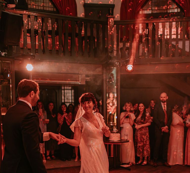 The bride wearing a sparkly gown has the first dance with the groom at The Bedford London wedding 