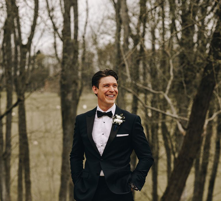 Groom in black tie suit with white buttonhole groom accessory 