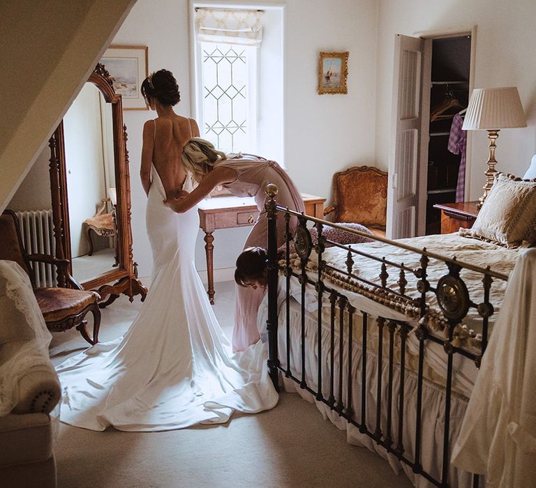 Bride getting ready putting on satin slip wedding dress 