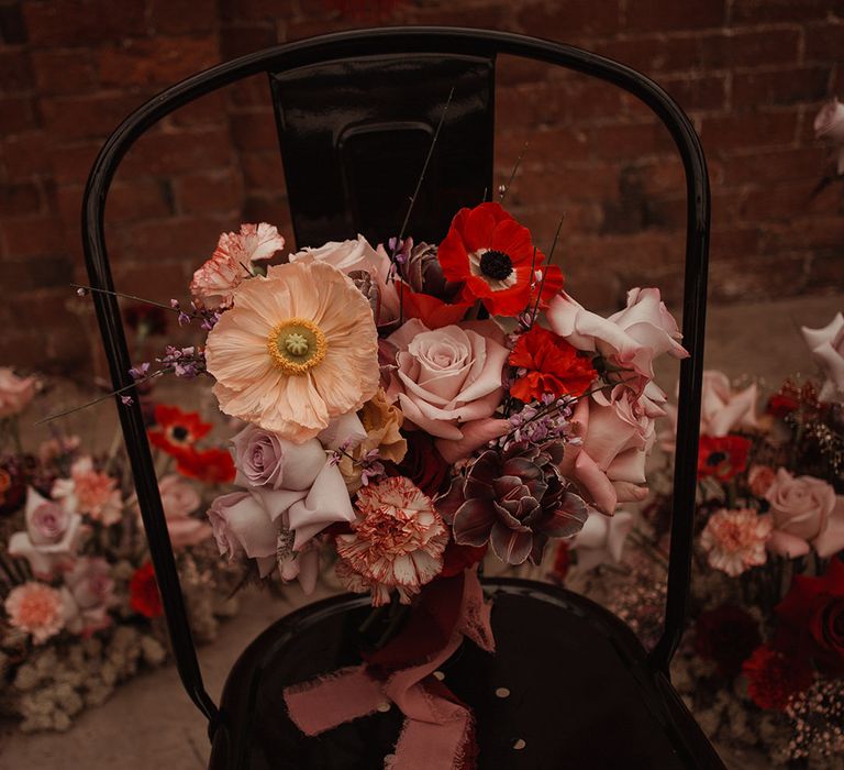 Anemones, poppies, roses and more flowers make up this Valentine's Day inspired wedding bouquet