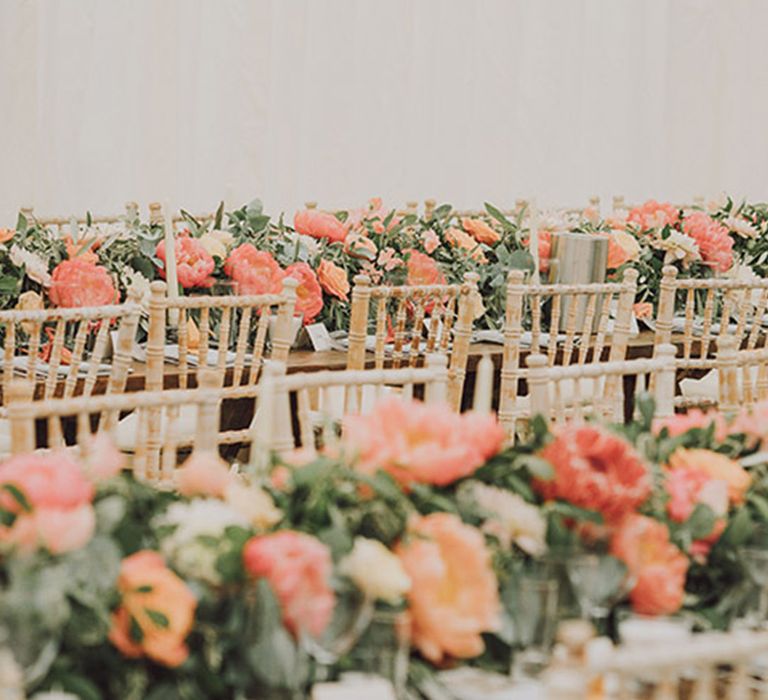 Marquee wedding with the tables filled with peach and coral wedding flowers for spring wedding