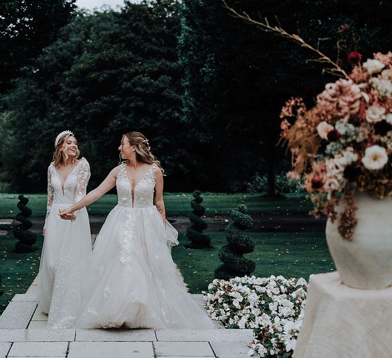 Two brides wearing lace princess wedding dresses at The Holford Estate Wedding 