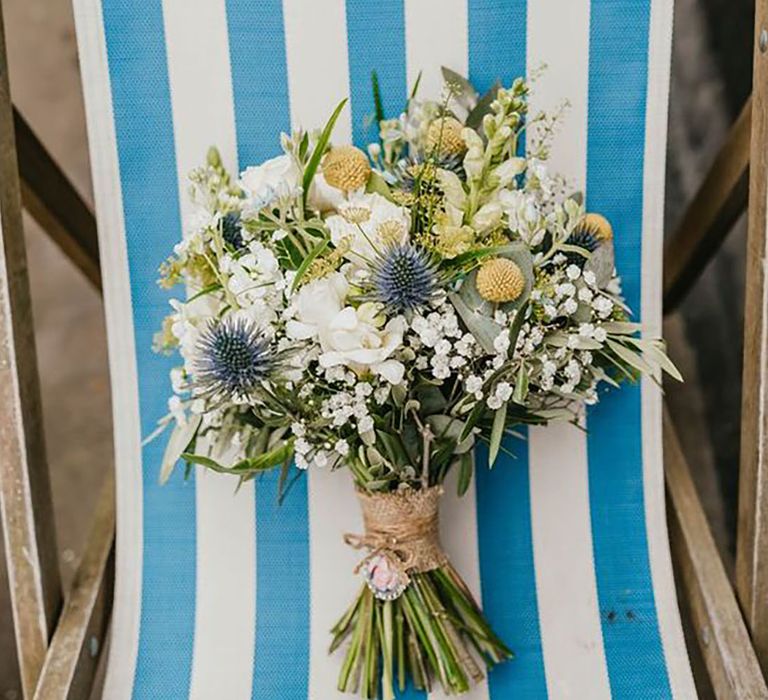 Image of a bouquet of flowers placed on a blue and white stripe deck chair by Shelby Ellis Photography