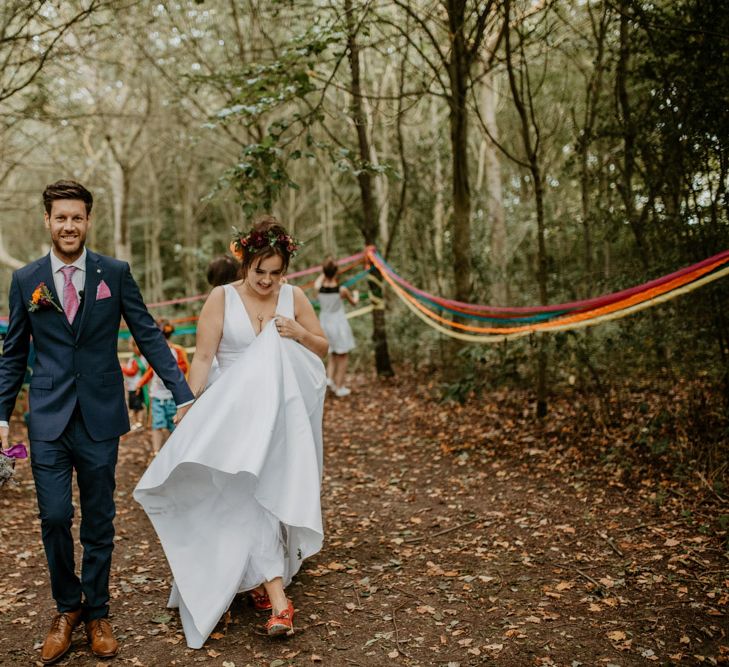 bride and groom walking through the forest by Camilla Andrea Photography