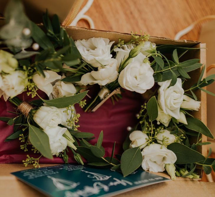 white buttonholes with foliage 