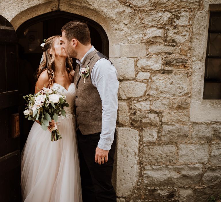 Bride and groom kissing outside the registry office 