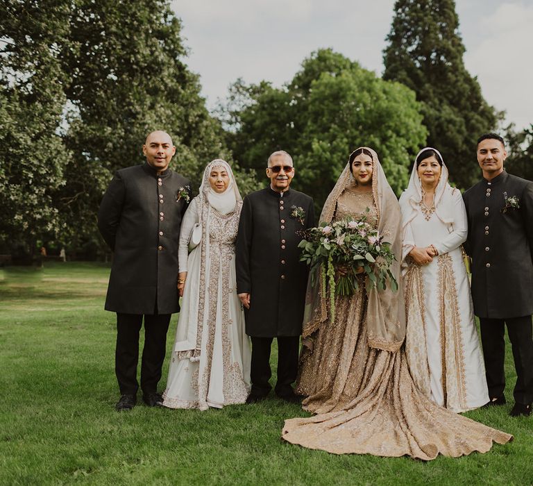 Portrait of the muslim bride in a gold wedding dress with her family 