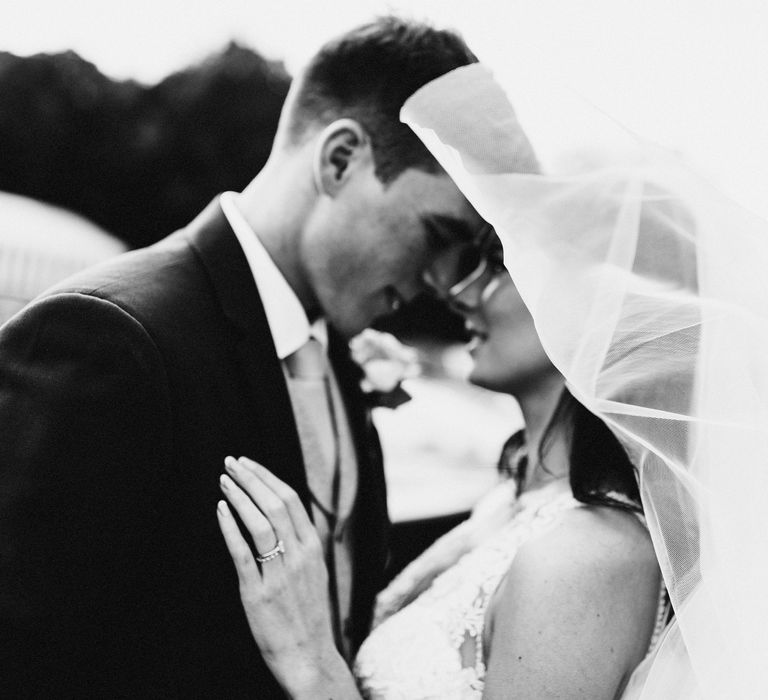 Veil blowing around bride & groom on wedding day 