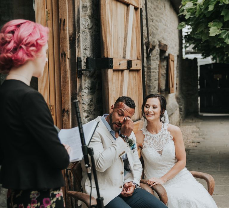 Groom wipes tear as celebrant carries out civil ceremony at The Tythe Barn