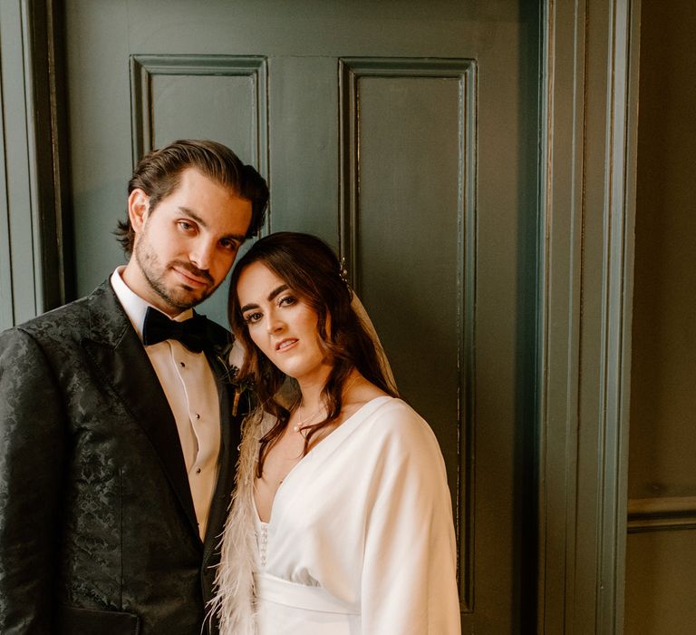 Groom wearing black bow tie bride wears Charlie Brear bridal gown 