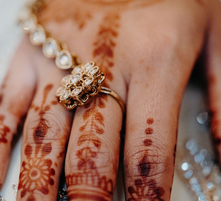 Bride wearing golden jewellery on Henna painted hands