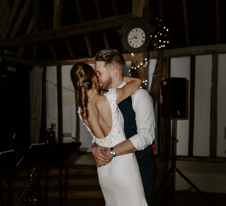 First dance wedding photography with the bride in a backless wedding dress with appliqué detail and curly ponytail wedding hairstyle 