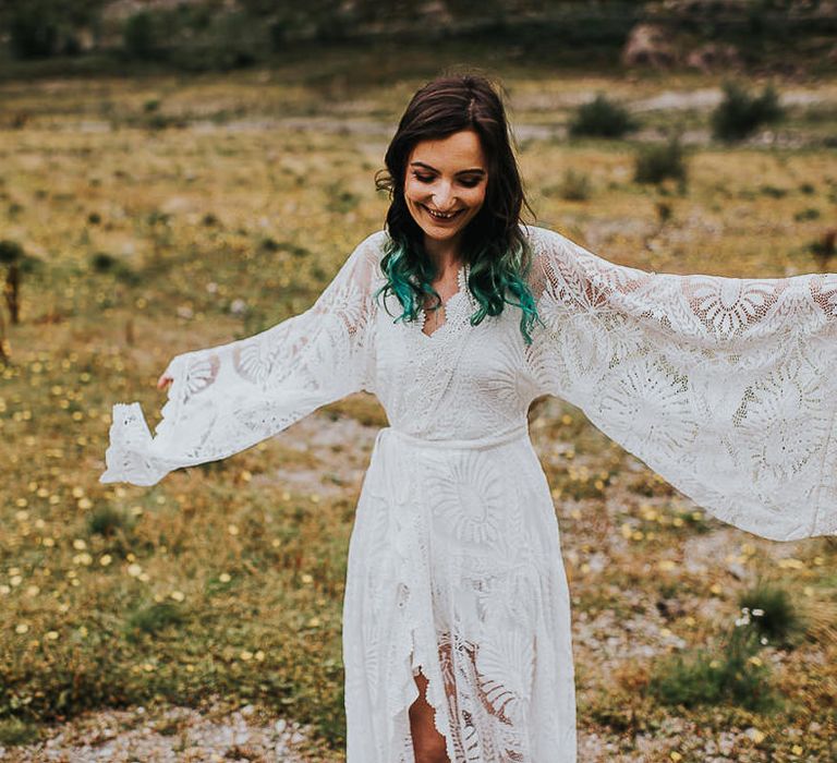 Ethereal bride walks through the countryside in the Lake District wearing bell sleeved wedding gown 