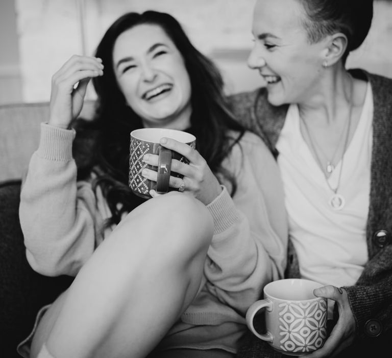 The brides on the sofa drinking coffee and laughing