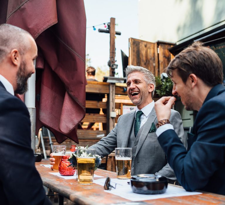 Wedding guests sit outside and laugh before wedding ceremony