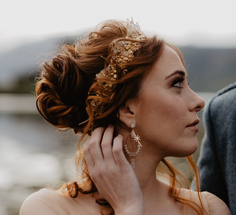 Red haired bride wears lace gown and gold crown in her hair