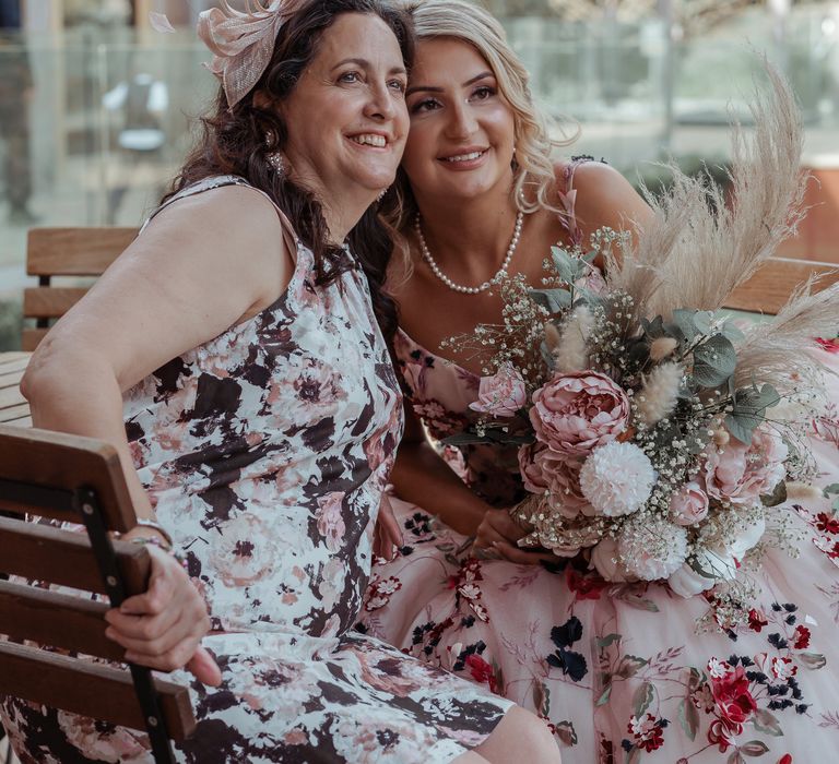 Bride sits with wedding guest on her wedding day