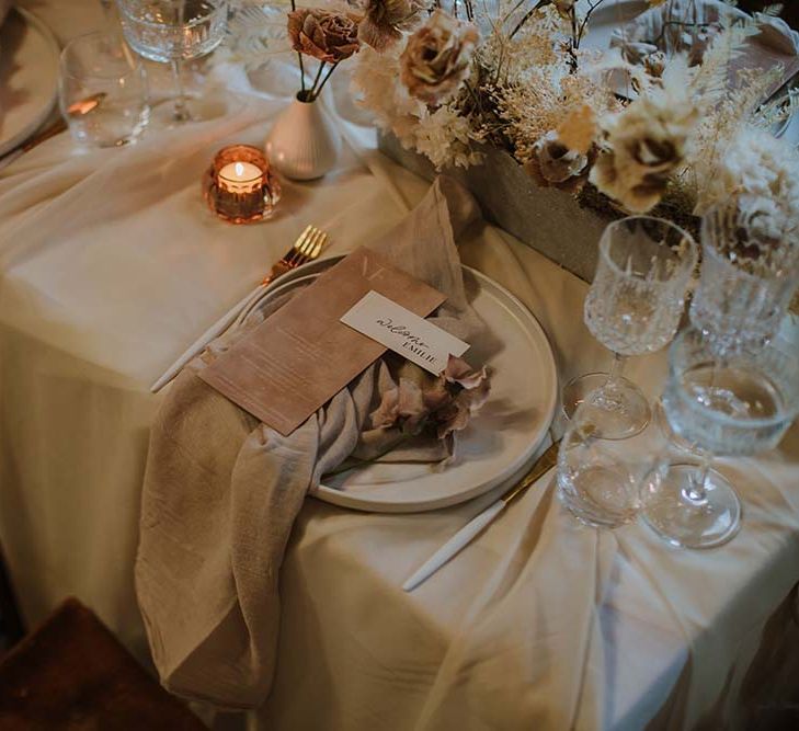 Neutral place setting decor with white cutlery, linen napkin, and contemporary on the day wedding stationery