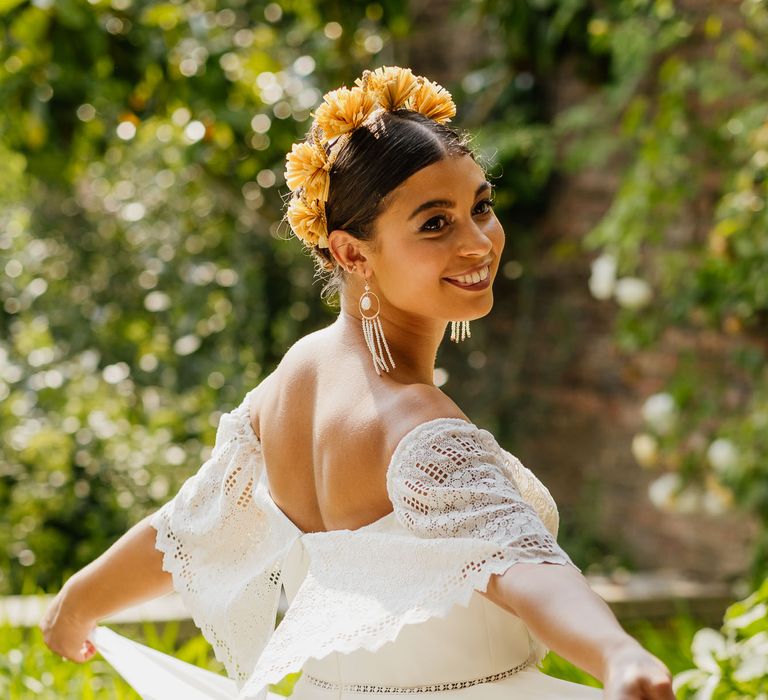 Boho bride twirling in a strapless wedding dress, yellow headband and tassel earrings 