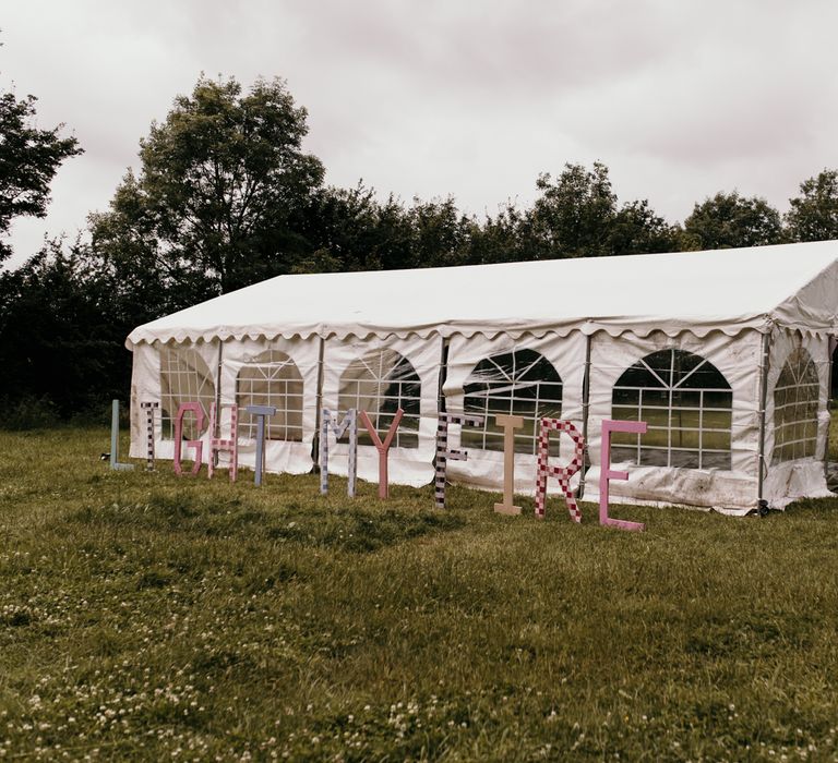 White marquee entrance with personalised large lettering outside