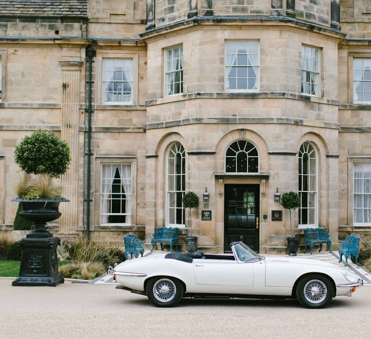 Vintage wedding car in front of the country house wedding venue 