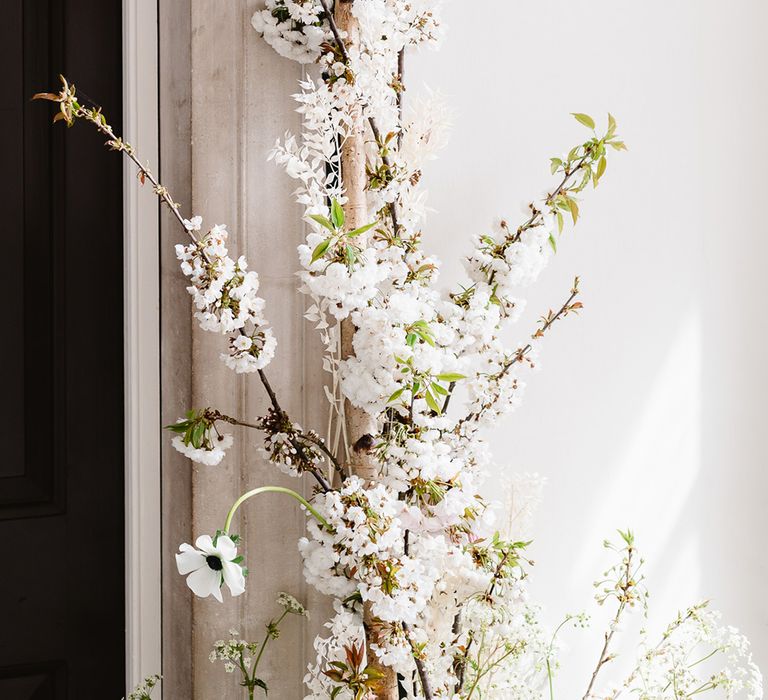 Close up shot of a wedding flower arch. The flowers are small and white.