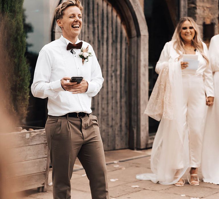 Brides watch as friend gives speech on their wedding day