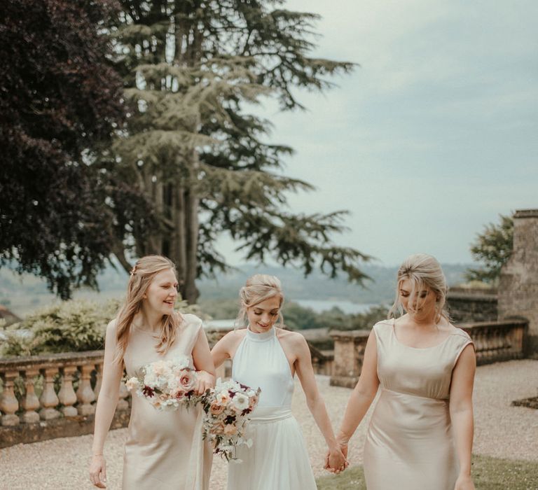 Bride and bridesmaids in champagne gold satin bridesmaid dresses by Ghost 