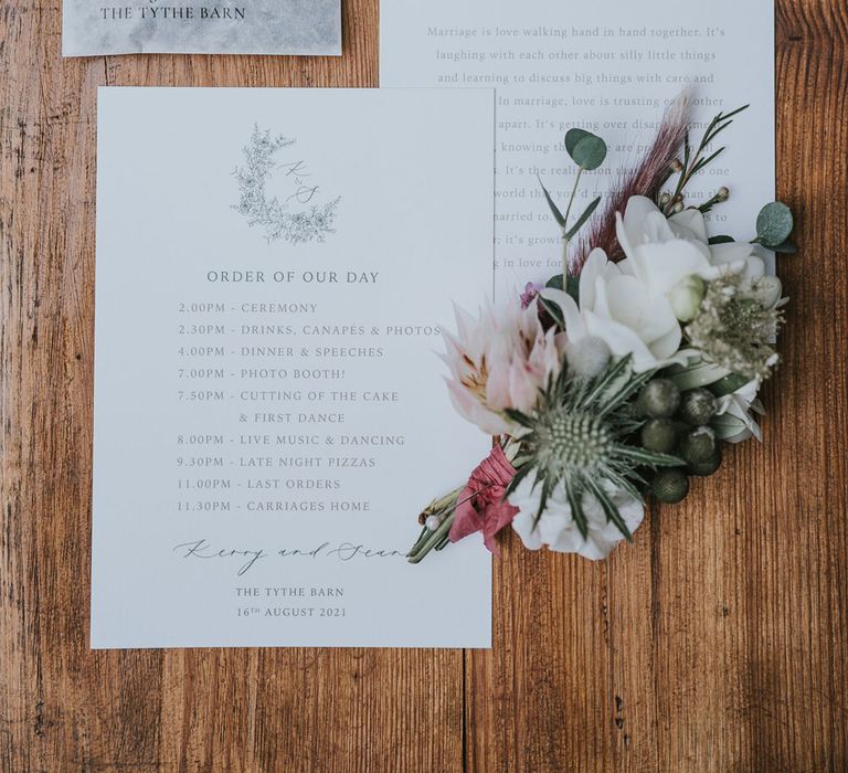 White order of the day and wedding reading, personalised wedding confetti and buttonhole with protea and white flowers at Tythe Barn wedding with barn wedding flowers