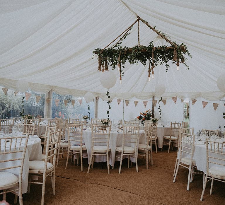 rustic marquee back garden wedding reception with bunting, balloons and hanging light installation 