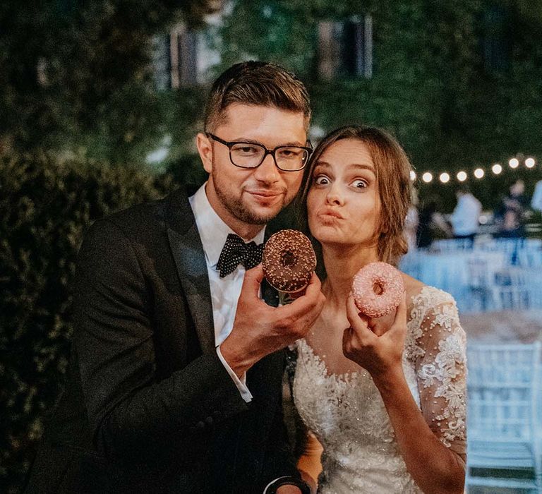 Bride & groom pose with donuts on their wedding day | Royal Studio