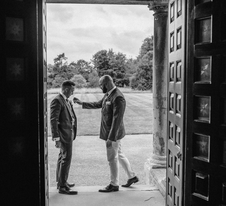 Groom stands with his groomsmen outside on his wedding day