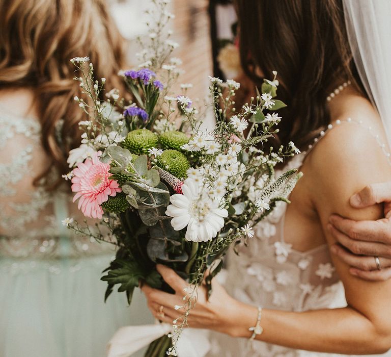 Bride holds white and pink floral bouquet 