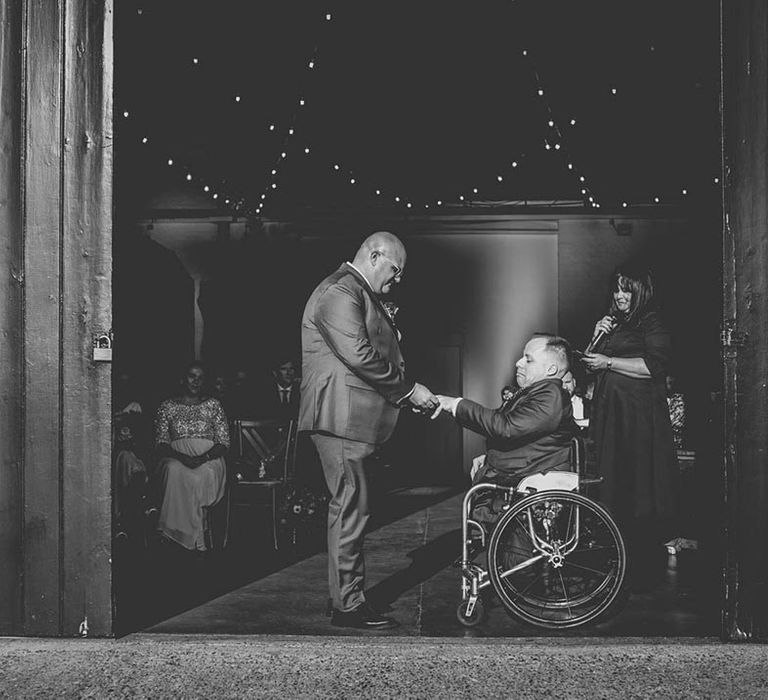 Grooms hold hands at industrial wedding at The Chainstore Trinity Buoy Wharf