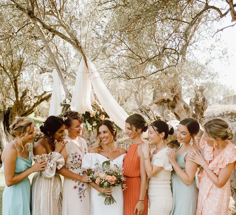 Smiling bride surrounded by her bridesmaids 