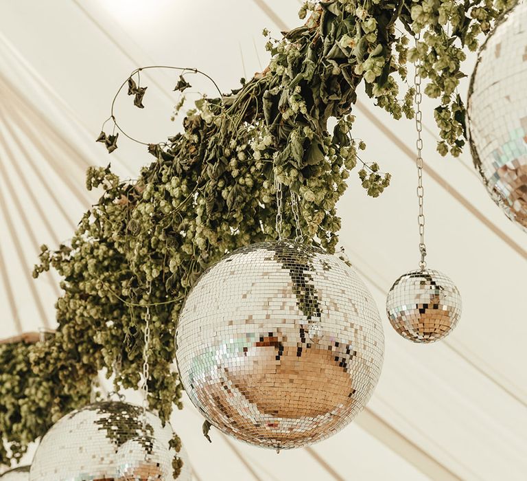 Greenery and different sized disco ball wedding decor for marquee wedding