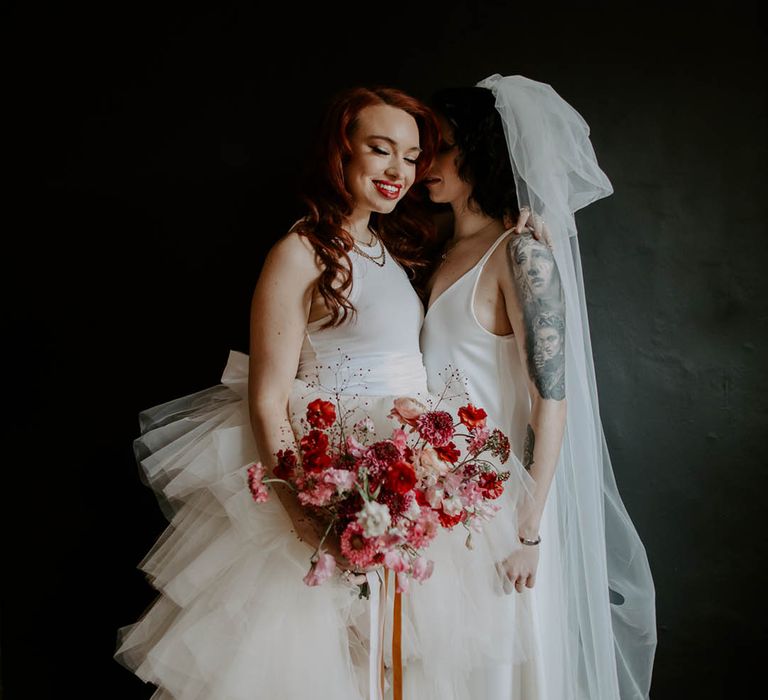 Two brides in a high low tulle skirt wedding dress and satin slip with long bow veil at Manchester elopement 